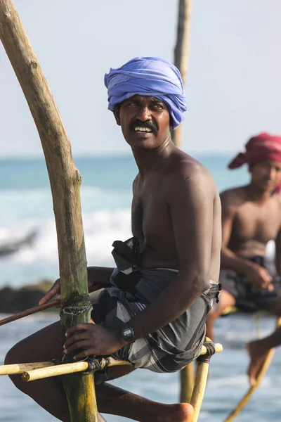 АХАНГАМА, ШРИ-ЛАНД-03 ЯНВАРЯ 2012 года: Местные рыбаки ловят рыбу в уникальном традиционном стиле. Стоять на единственном деревянном столбе или столбе можно только в этом Индийском океане . — стоковое фото