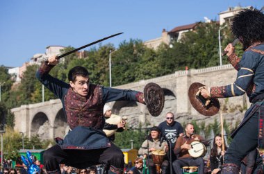 Gürcistan, Tiflis-07 Ekim 2017: Gürcü milli kostümlü savaşçılar bıçak, kılıç ve kalkan taşıyor ve Tiflis bayramında savaşıyorlar. Ekim festivali