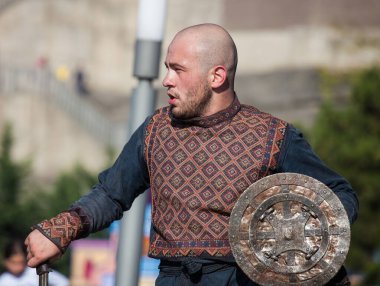 Gürcistan, Tiflis-07 Ekim 2017: Gürcü milli kostümlü savaşçılar bıçak, kılıç ve kalkan taşıyor ve Tiflis bayramında savaşıyorlar. Ekim festivali