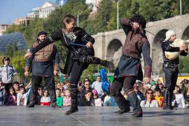 Gürcistan, Tiflis-07 Ekim 2017: Gürcü milli kostümlü savaşçılar bıçak, kılıç ve kalkan taşıyor ve Tiflis bayramında savaşıyorlar. Ekim festivali