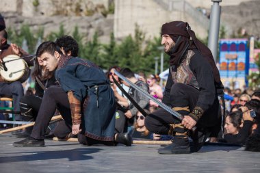 Gürcistan, Tiflis-07 Ekim 2017: Gürcü milli kostümlü savaşçılar bıçak, kılıç ve kalkan taşıyor ve Tiflis bayramında savaşıyorlar. Ekim festivali