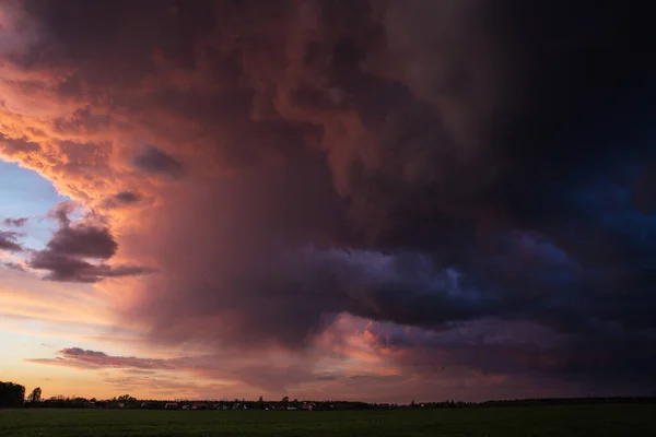 Landschap met majestueuze kleurrijke dramatische rode hemel met pluizige wolken bij zonsondergang voor een onweersbui en regen met het ruime veld. — Stockfoto