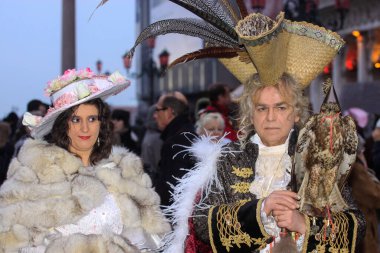 VENICE, İtalya - 15 Şubat 2010: Dünyanın en ünlü ve en çok ziyaret edilen şehirlerinden biri olan Venedik 'teki yıllık karnavalda maskeler. İnsanlar ziyarete ya da güzel el yapımı kostümlerini göstermeye geliyor..