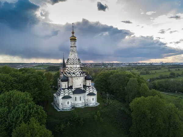 Vista aérea do verão da igreja solitária branca que está em uma colina entre campos verdes e rio. Rússia — Fotografia de Stock