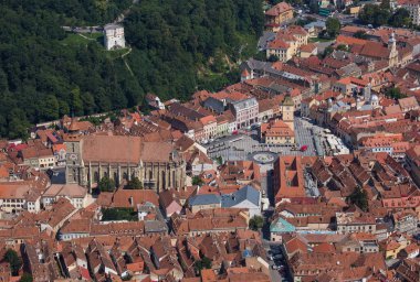 Romanya 'nın Transilvanya kentindeki ortaçağ Brasov kasabasının kırmızı kiremitli çatıları üzerinde hava manzarası. Avrupa