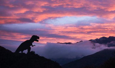 Kretase döneminde gün doğumunda bir tyrannosaurus rex silueti
