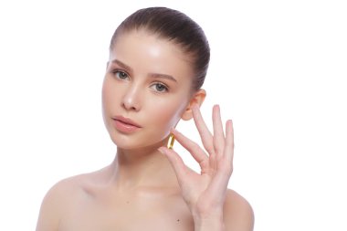 Balık yağı hapı elinde tutan güzel genç kadın. Sağlıklı beslenme kavramı.