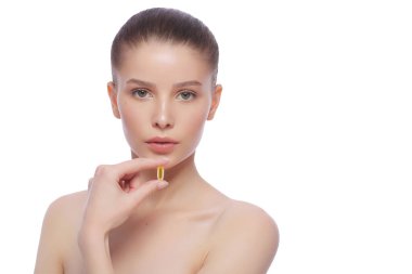 Balık yağı hapı elinde tutan güzel genç kadın. Sağlıklı beslenme kavramı.