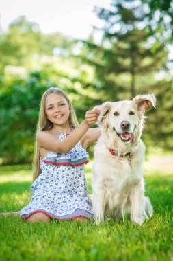 Parkta altın retriever köpek ile küçük kız