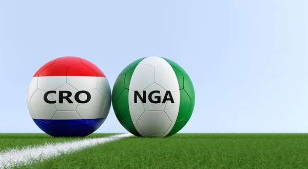 Croatia vs. Nigeria Soccer Match - Soccer balls in Croatia and Nigeria national colors on a soccer field. Copy space on the right side - 3D Rendering