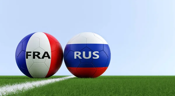 Russia vs. France Soccer Match - Soccer balls in France and Russia national colors on a soccer field. Copy space on the right side - 3D Rendering