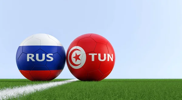 Russia vs. Tunisia Soccer Match - Soccer balls in Russia and Tunisia national colors on a soccer field. Copy space on the right side - 3D Rendering