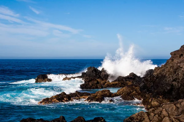 Büyük dalga kayaların üzerine sıçramasına gürültüyle çarpmak — Stok fotoğraf