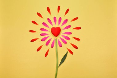 Yazı için yeri olan bahar çiçekleri. Kalpli çiçek arkaplanı. Yapraklardan güzel bir çiçek. Sarı arka planda pembe yapraklar. Çiçek yaprakları ve kalp.