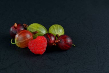 Siyah arka planda çeşitli böğürtlenler. Sulu yabanmersinleri.