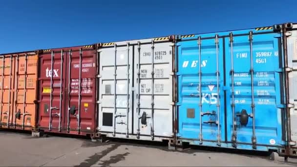 モスクワ ロシア 2019年4月20日 出荷コンテナの行 異なる色の輸送容器の数は 青い空に対して地面に立っています — ストック動画