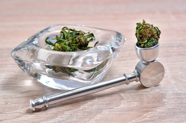 Kuru kenevir çiçeklenmeleri ve tıbbi marihuana sigara cihazları.