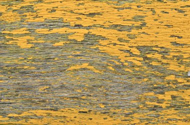 Eski ahşap bir yüzey üzerinde eski püskü, sarı boya dokusu