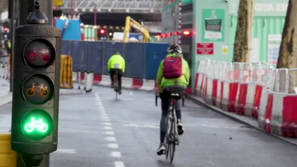 Radfahrer fahren in London auf viel befahrenem Radweg mit Fahrradampel durch Baustelle — Stockvideo