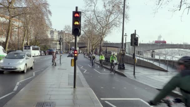 Cyklisté jezdit v náročném cyklu lane v Londýně s cyklu semafory řeky Temže a provoz — Stock video