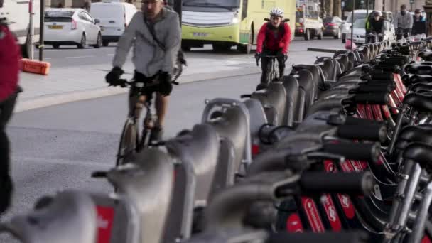 Fietsers rijden langs stadsfietsen van de huren in Londen naast verkeer — Stockvideo