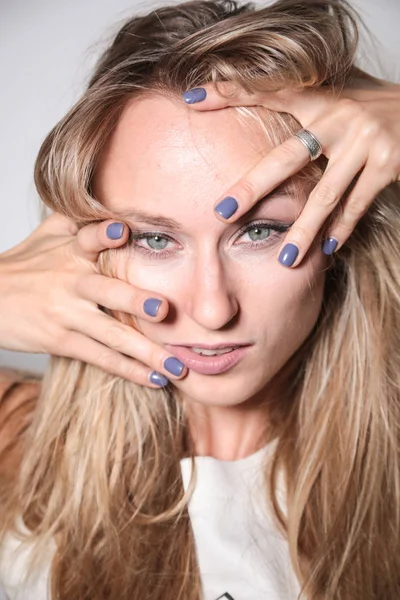 Genç manken okuyucuya bakarken yüzünü kapatıyor.