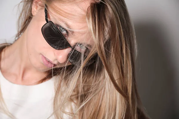 Genç model güneş gözlüklerinden bakıyor.