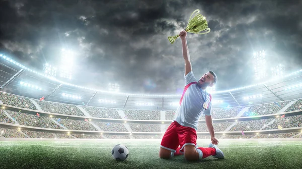 El jugador de fútbol tiene un trofeo de una mano. Medalla en el cuello — Foto de Stock