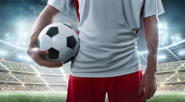 Stadyum üzerinde futbol topu tutan futbolcu yakın çekim