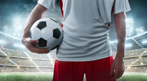 Jugador de fútbol sosteniendo pelota de fútbol en el estadio — Foto de Stock