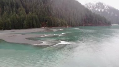 Bir yağmurlu kış gününde Alaska'da küçük dalgalar sörf çalışıyor