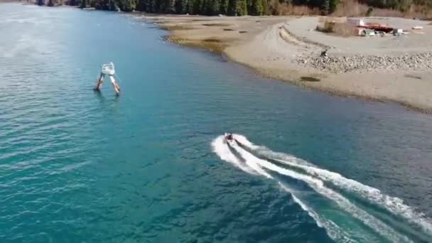 アラスカのビーチに沿って濡れ自転車に乗るジェットスキーヤー — ストック動画