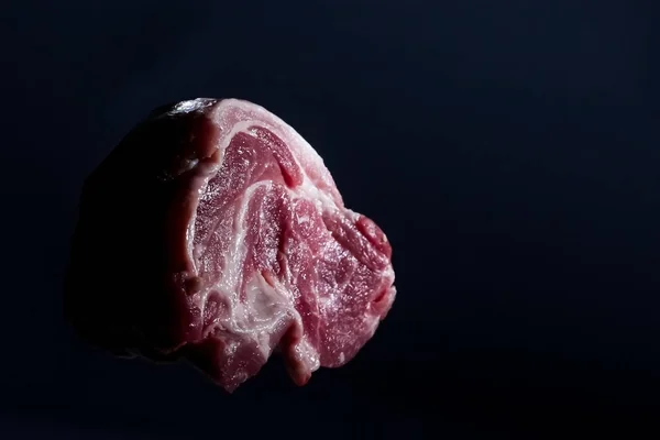 Κομμάτι κόκκινο νωπό χοιρινό λαιμό κρέας σε σκούρο φόντο — Φωτογραφία Αρχείου
