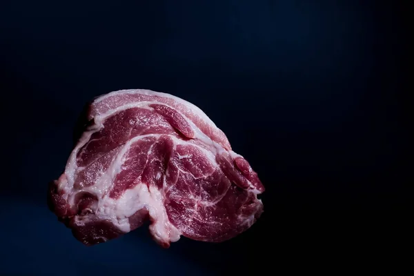 Шматок червоної сирої свинячої шиї м'ясо на темному фоні — стокове фото