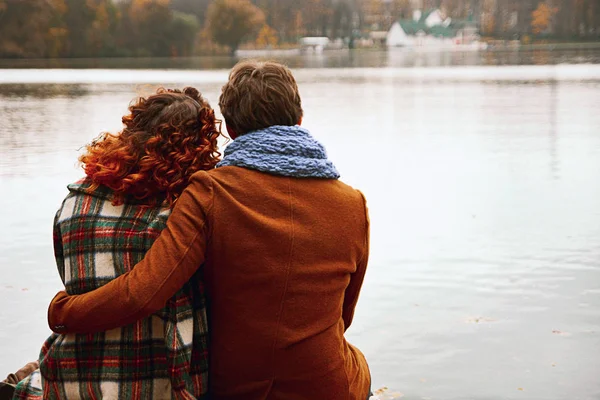 Pareja está abrazando sentado en el puente — Foto de Stock