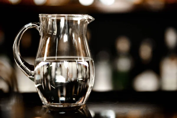 Jug with crystal clear water on a dark background — Stock Photo, Image