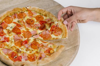 Erkeklerin elleri bir dilim pizza alır.