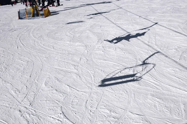 På bergssidan skuggorna av skidåkare som går upp på Ski-Li — Stockfoto