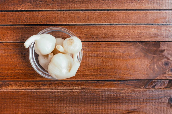Acar bawang putih pada latar belakang coklat — Stok Foto