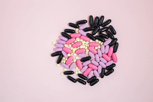 colorful pills on pink background