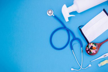 Üst ya da düz yüz maskesi, dezenfektan el jeli, stetoskop, tabletler, Coronavirus ya da COVID-19 'dan korunmak için termometre ve günlük yaşam ve çalışma için gerekli malzemeler. Sağlık koruma kavramı için kişisel eşya.