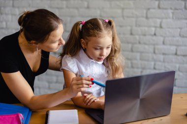Annesiyle mutlu bir kız evde online çalışıyor. Corona virüsü ve karantina konsepti. Çevrimiçi öğrenme veya eğitim teknolojisi kavramı