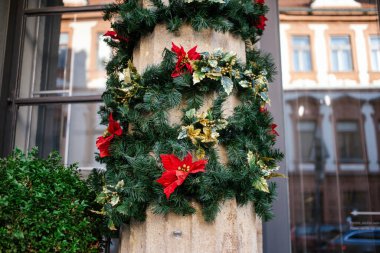 Şehir caddesi açıklığı dekore edilmiş Noel şubesi kırmızı çiçeklerle kapanıyor.