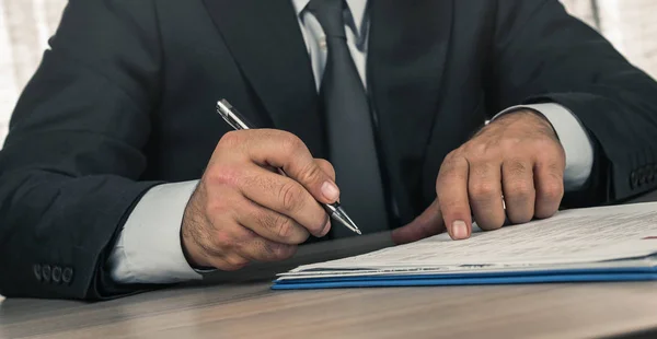 man working in office signing agreement
