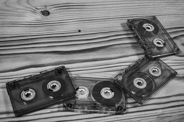 Audio cassette on a wooden table in black and white.