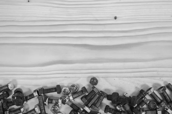 Old bolts and nuts on a wooden table. — Stock Photo, Image