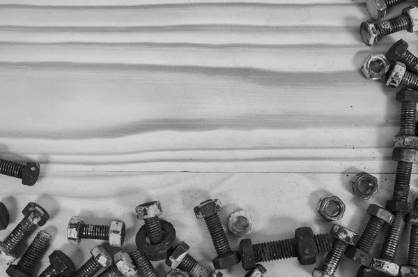 Oude bouten en moeren op een houten tafel. — Stockfoto