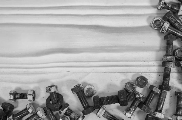 Vieux boulons et écrous sur une table en bois . — Photo