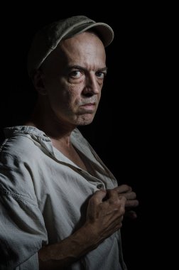 Karanlık bir arka plan üzerinde şapkalı yaşlı bir adam portresi .