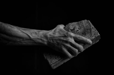 Adamın elinde bir tuğla, siyah-beyaz holding.